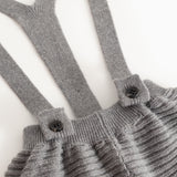 Gray suspenders with buttons and gathered chest piece on knitted pants