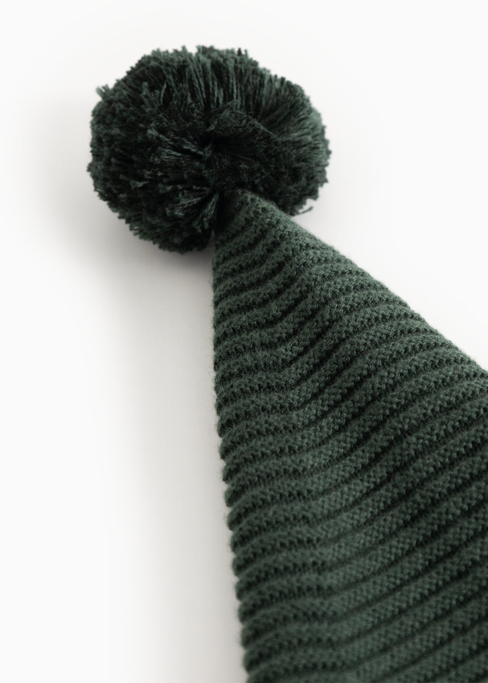 Knitted dark green elf hat with pompom and distinct ribbed pattern