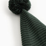 Knitted dark green elf hat with pompom and distinct ribbed pattern