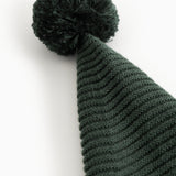 Knitted dark green elf hat with pompom and distinct ribbed pattern