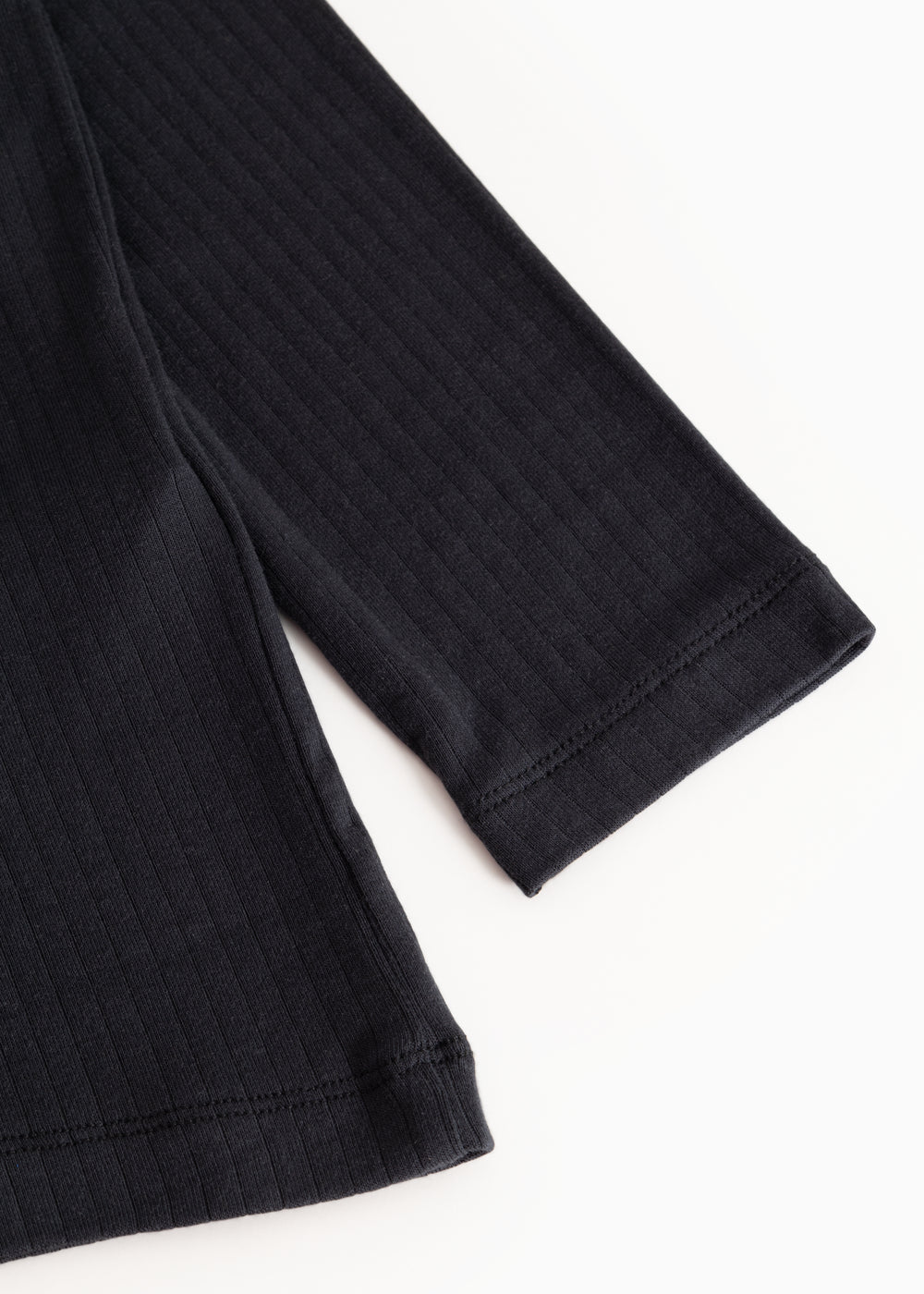 Sort ribbed-sleeve T‑shirt with ribbed texture and cuff.