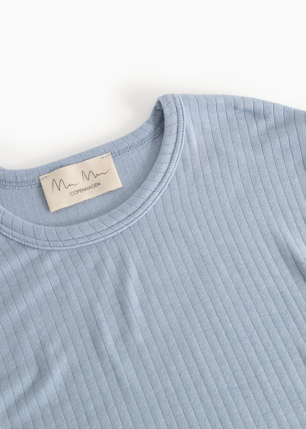 Light blue long-sleeve T‑shirt, crew neck and tag at the collar.