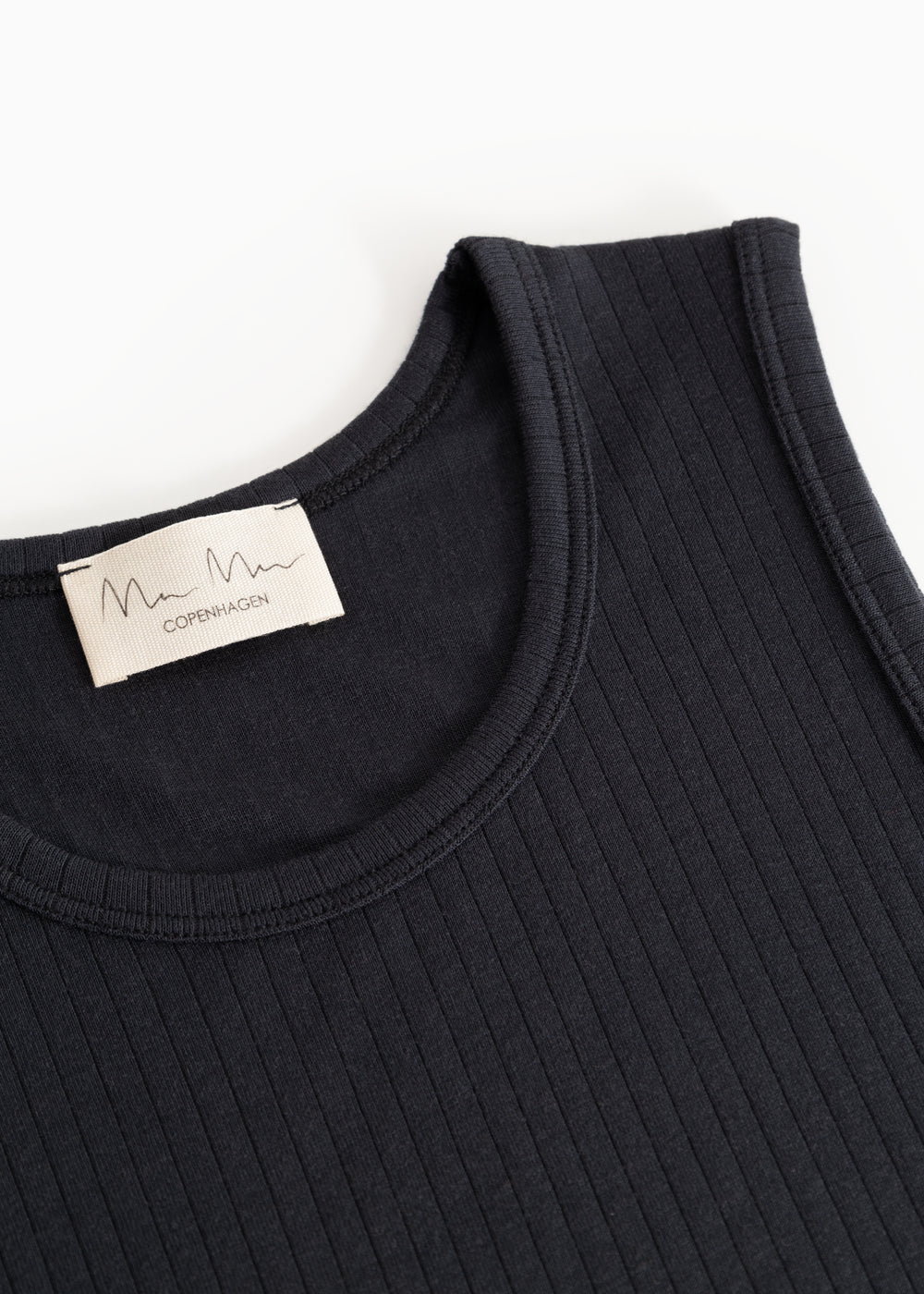 Sort tank top with round neckline and visible label at the collar.