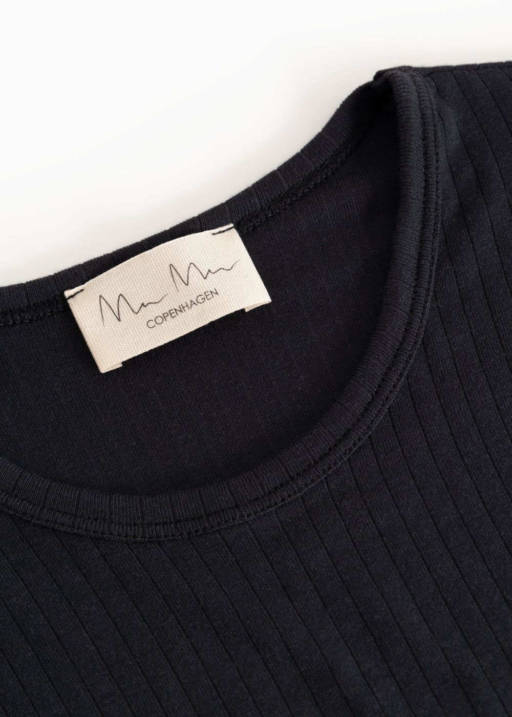Sort coat with round collar and inner tag in the neck.