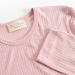 Pink evening dress with round neckline, ribbed fabric, and brand label at the collar.