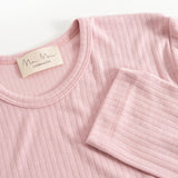 Pink evening dress with round neckline, ribbed fabric, and brand label at the collar.