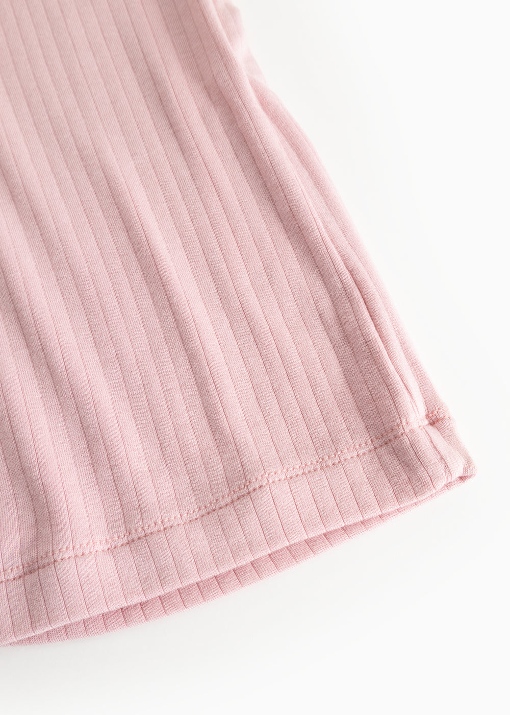 Pink evening dress with ribbed pattern, close-up of the bottom edge.