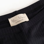 Pants with black ribbed fabric and "m Copenhagen" label at the waist.