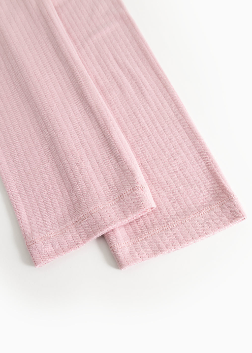 Pink pants with ribbed texture and folded edge at the leg opening.