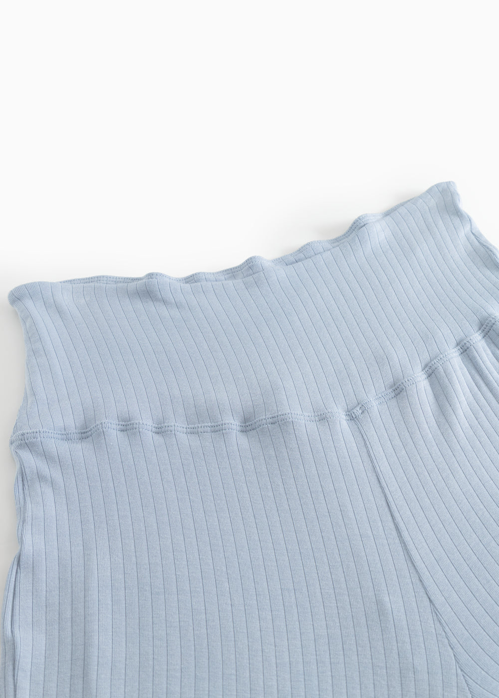 Light blue trousers with ribbed texture and wide elastic at the waist.