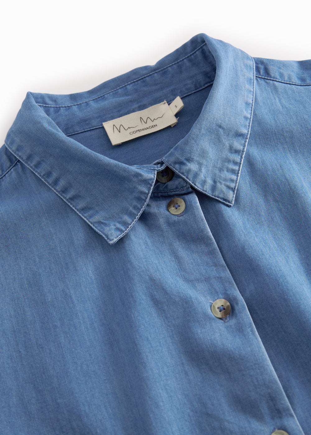 Blue denim ladies' shirt with long sleeves and chest pockets.