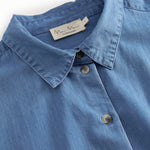 Blue denim ladies' shirt with long sleeves and chest pockets.