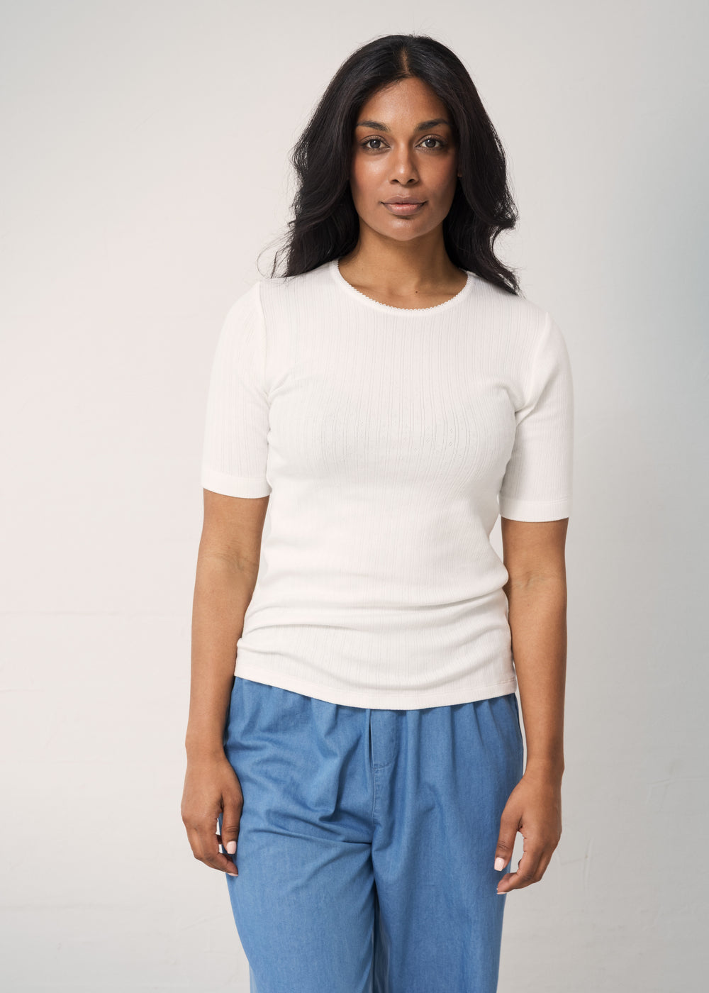 Woman wearing blue jeans with a loose fit and a white t-shirt