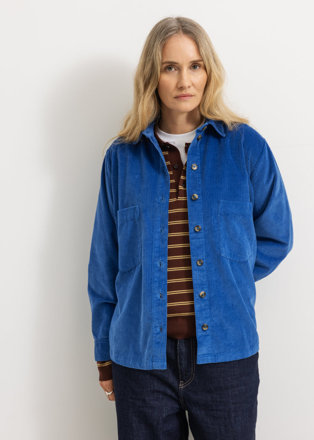 Blue shirt on model with collar and buttons, long sleeves and chest pocket.