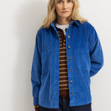 The striped polo shirt is visible under a blue jacket, button collar, and dark stripes.