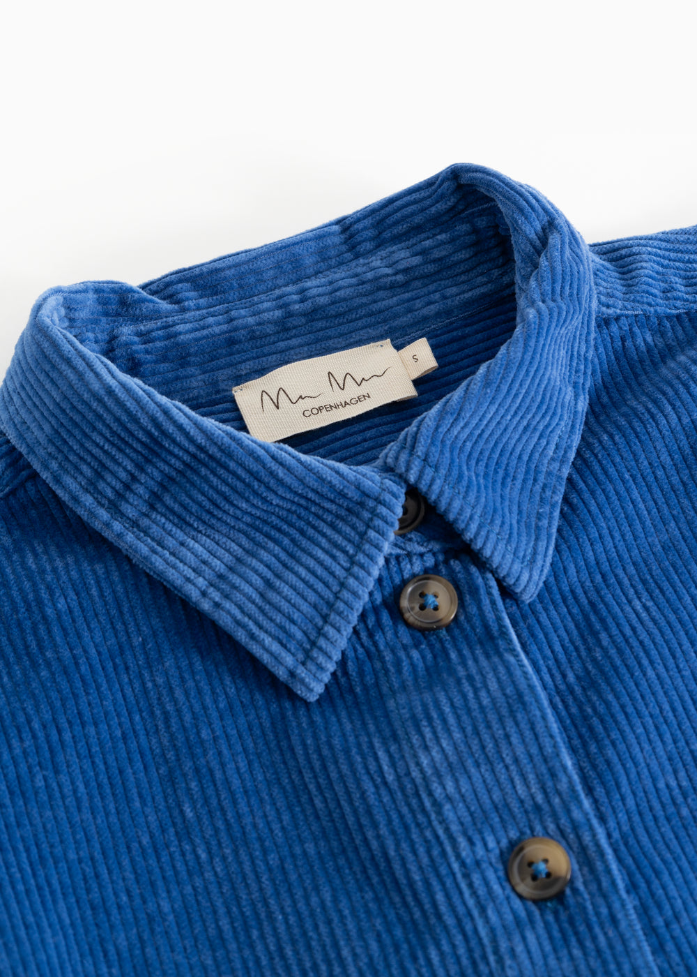 Blue corduroy shirt with collar, button closure, and visible fabric texture.