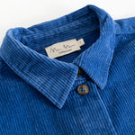 Blue corduroy shirt with collar, button closure, and visible fabric texture.