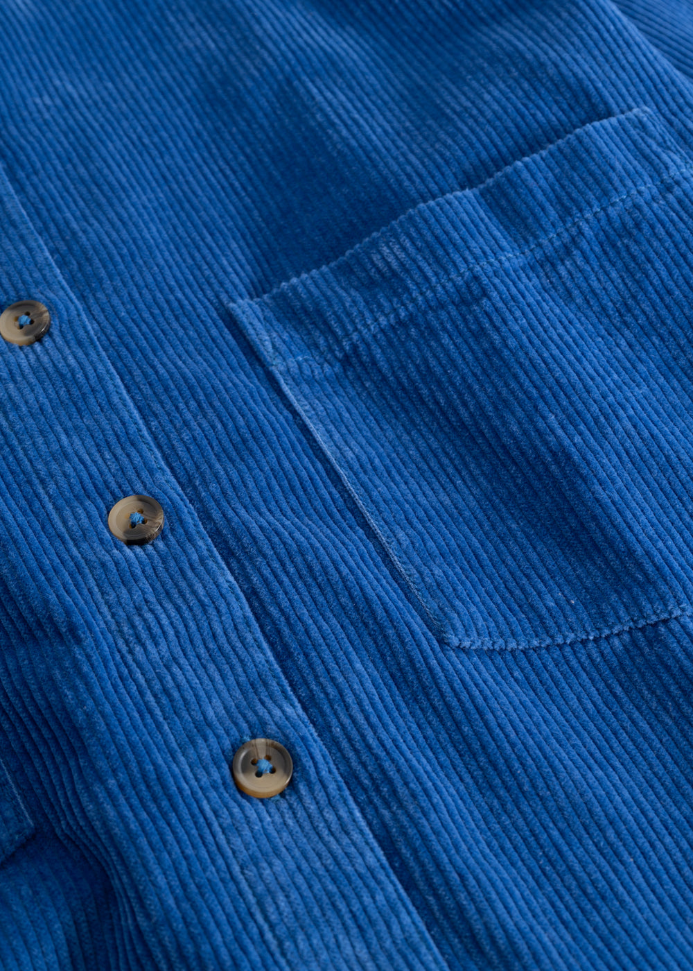 Blue button-down shirt with buttons, chest pocket, and highlighted seams.