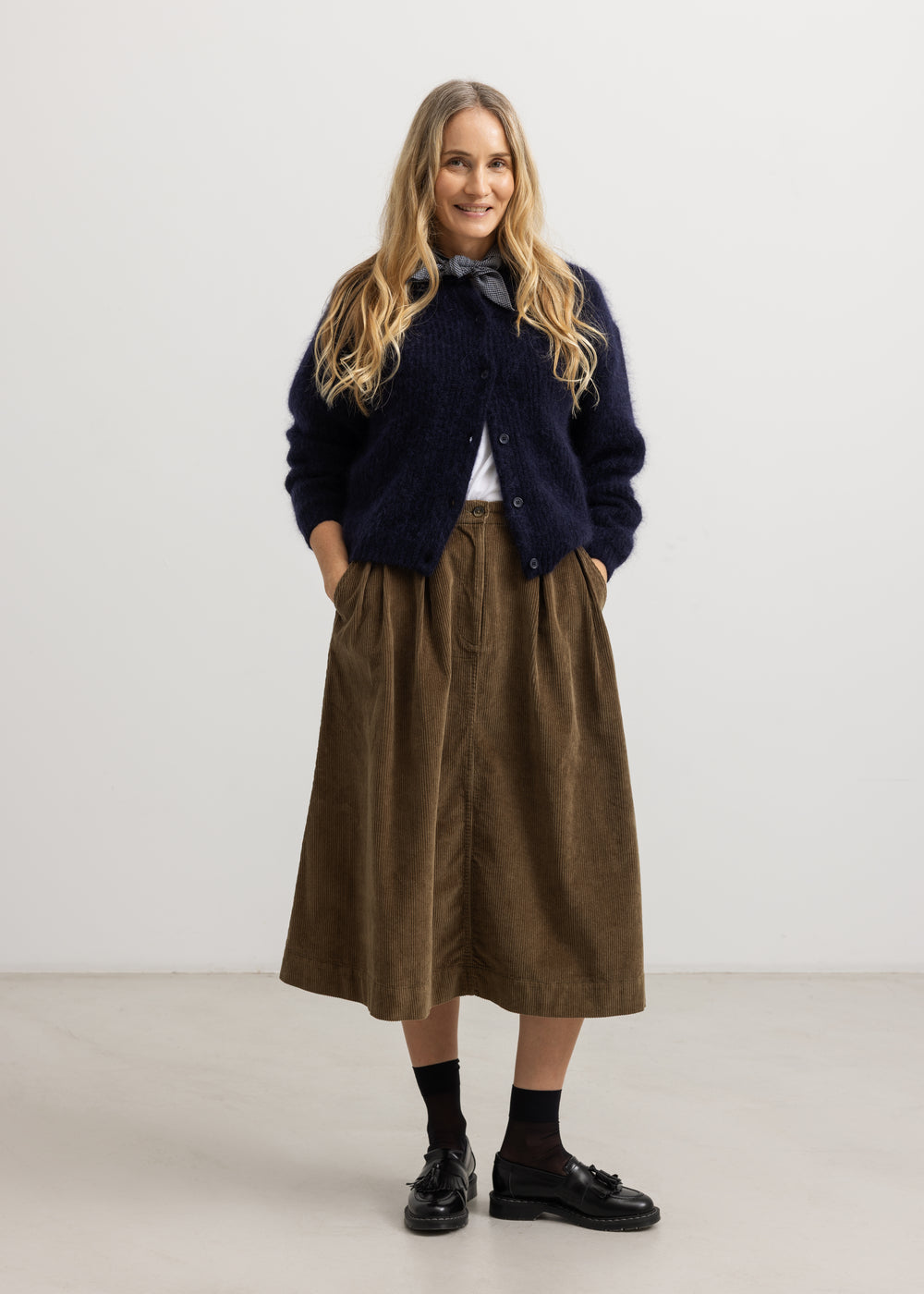 Brown bottom with pleated folds and button closure at the waist.