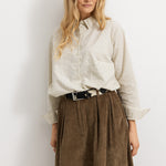 Brown lower part with wide folds and hidden button closure, lightweight A‑form.