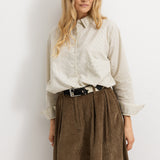 Brown lower part with wide folds and hidden button closure, lightweight A‑form.