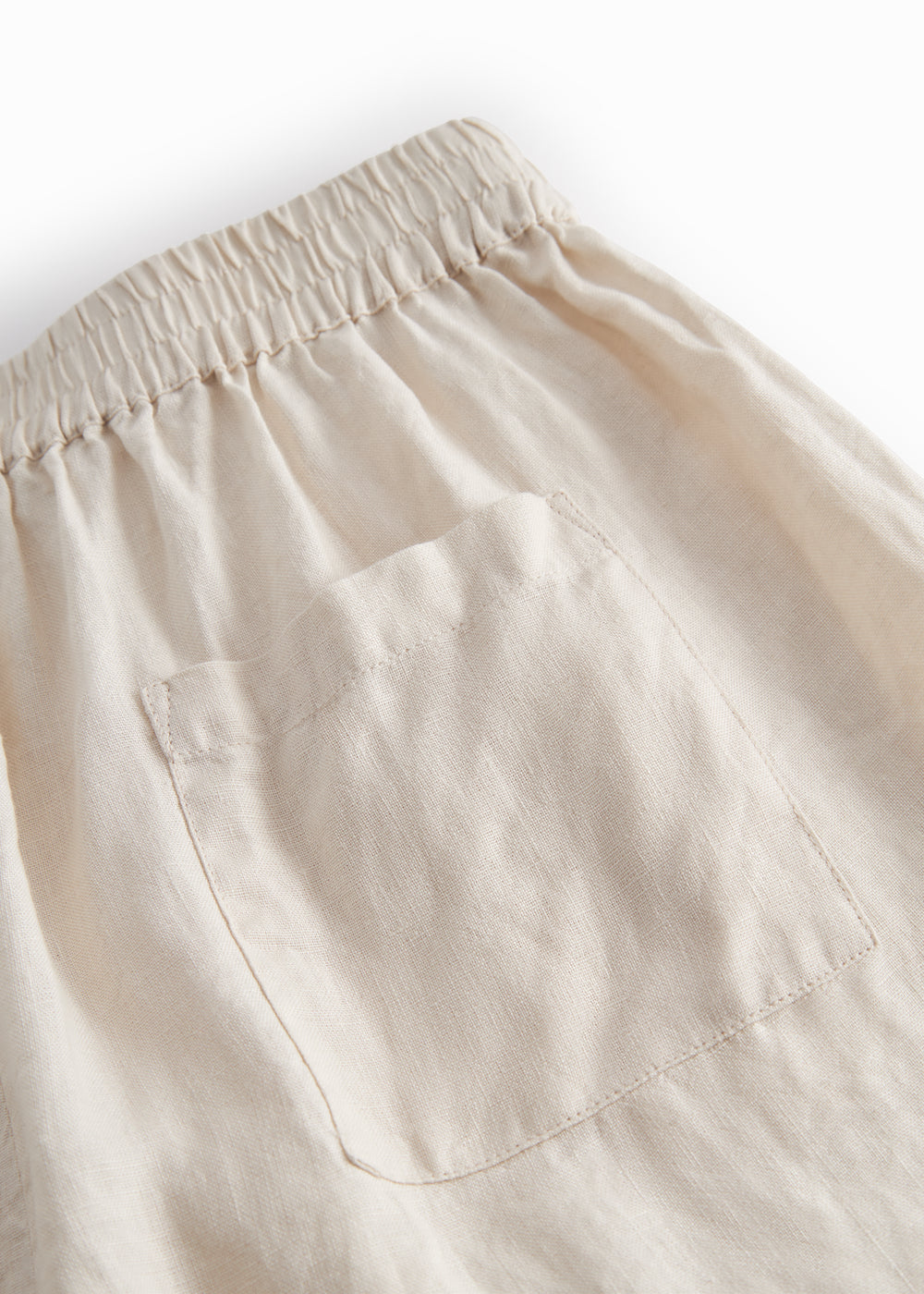 Beige shorts for women with side pockets, elastic at the waist, and a back pocket.