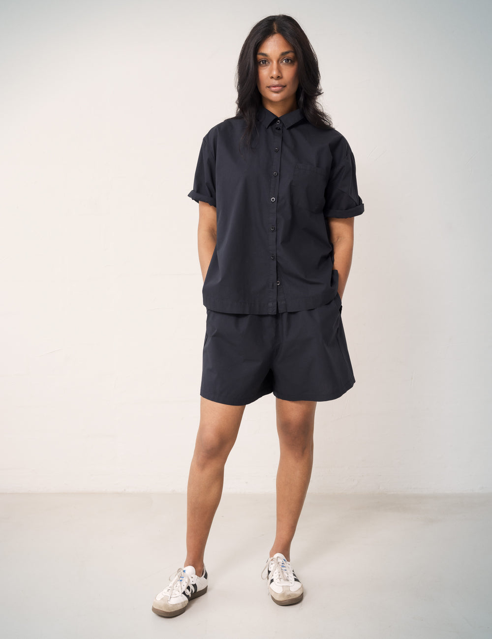 Woman wearing a short-sleeved black shirt and matching shorts