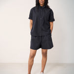 Woman wearing a short-sleeved black shirt and matching shorts