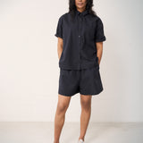 Woman wearing black shorts and a matching shirt.