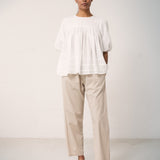 Woman in white shirt blouse and beige trousers