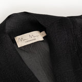 Short dress with round neckline and label at the back of the neck, visible fabric texture