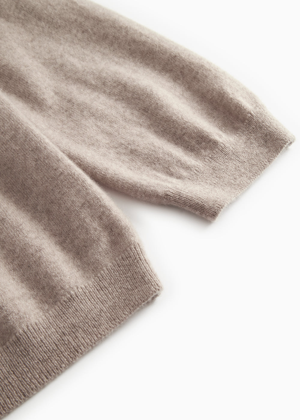Knitted cuff and hem on a gray melange cardigan with ribbing.