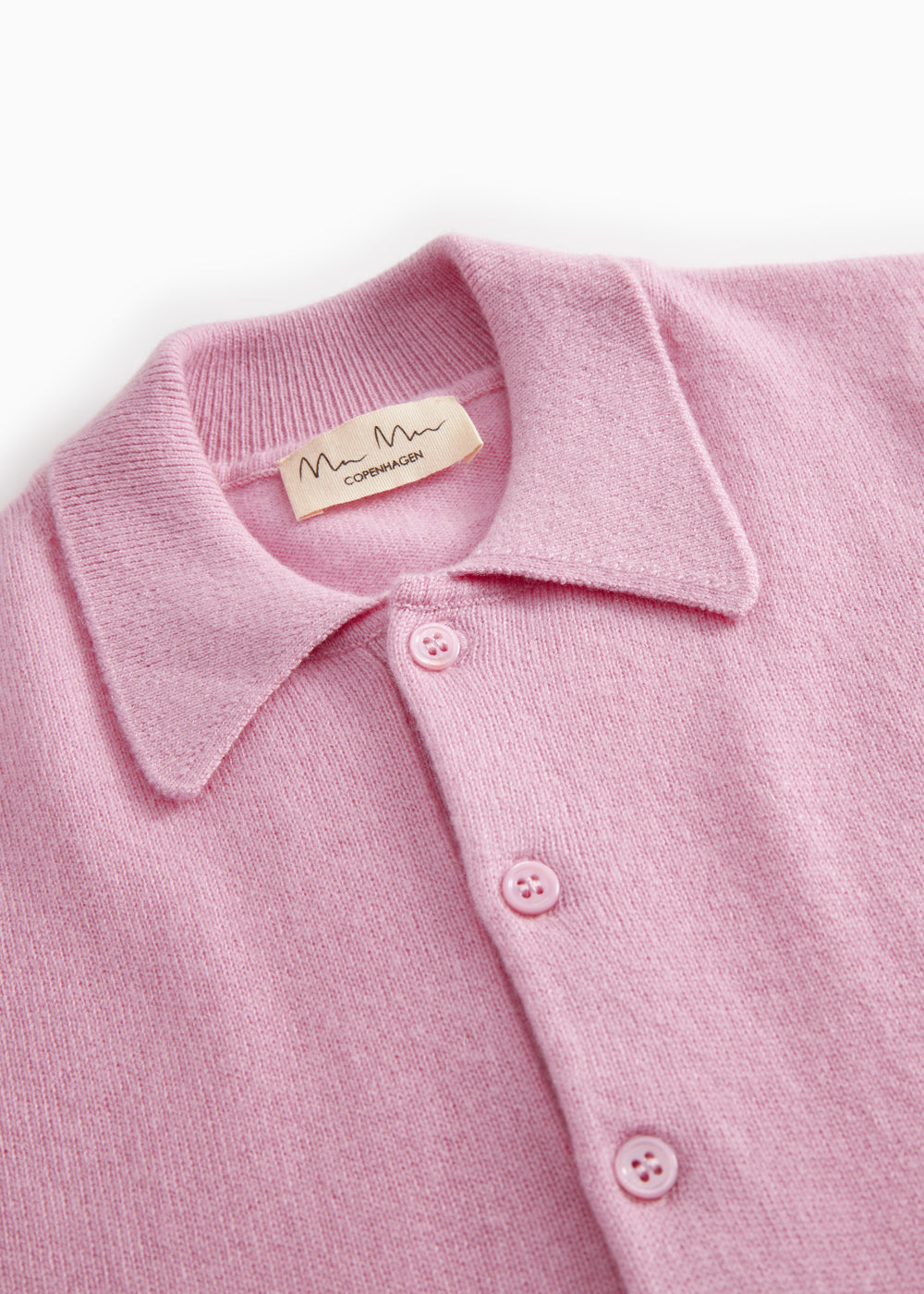 Pink polo shirt close to: collar and three buttons on the button placket