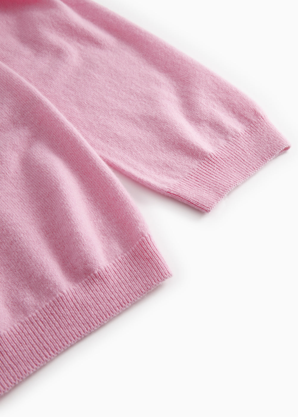 Pink polo with ribbed cuffs and hem in a folded detail.