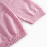 Pink polo with ribbed cuffs and hem in a folded detail.