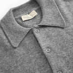 Gray melange cashmere polo: collar, button placket and brand badge at the neck.
