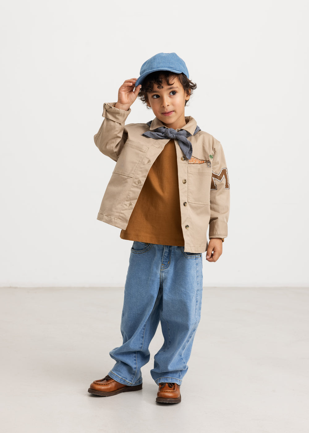 Long-sleeved blouse in deep caramel brown with button closure, chest pocket, and neck tie.