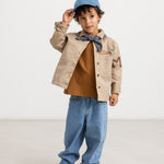 Long-sleeved blouse in deep caramel brown with button closure, chest pocket, and neck tie.