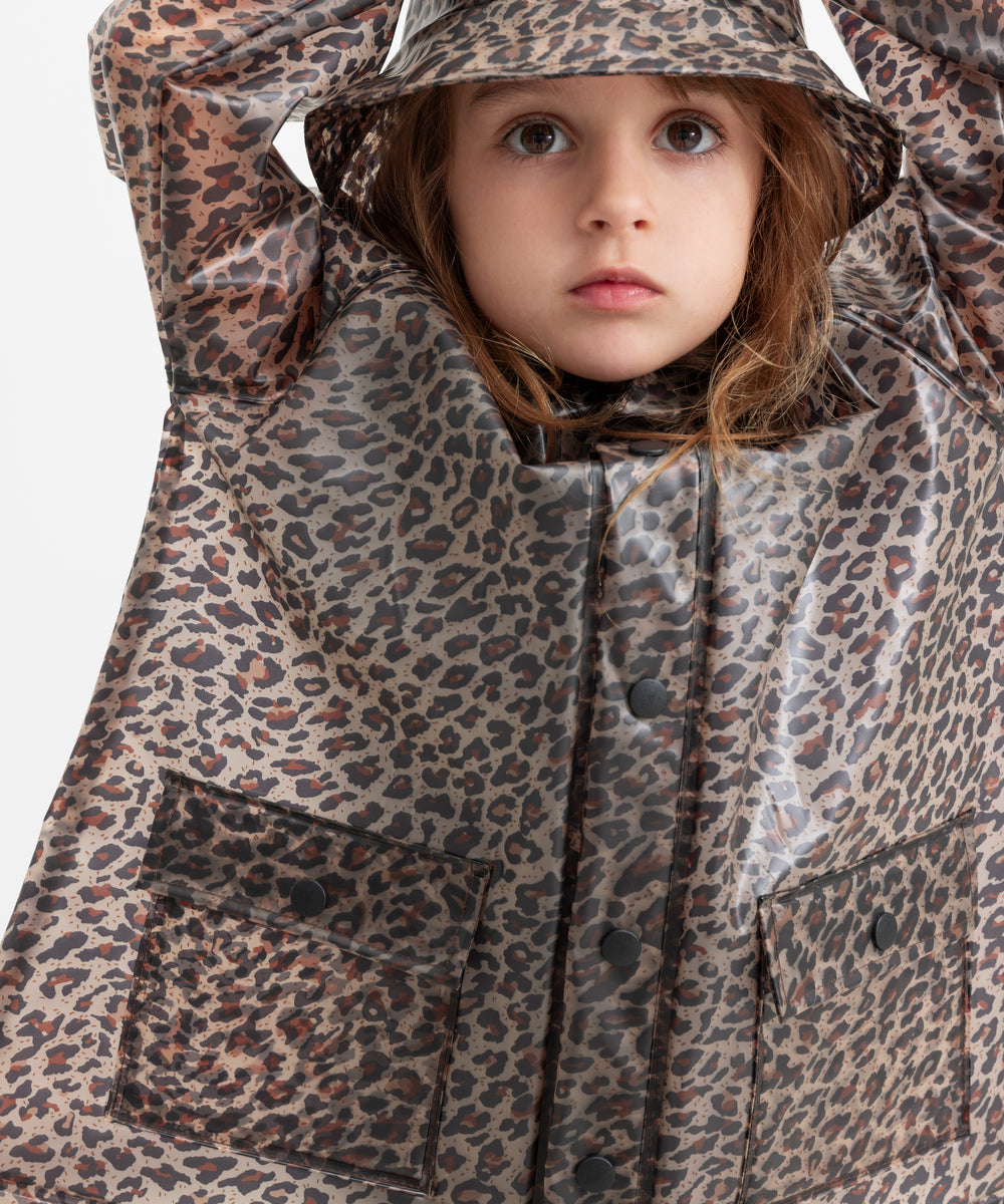Barn iført leopardmønstret regnjakke og regnhat