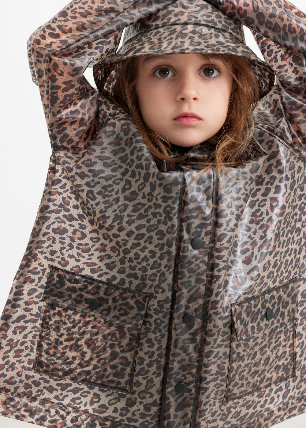 Barn iført leopardmønstret regnjakke og regnhat