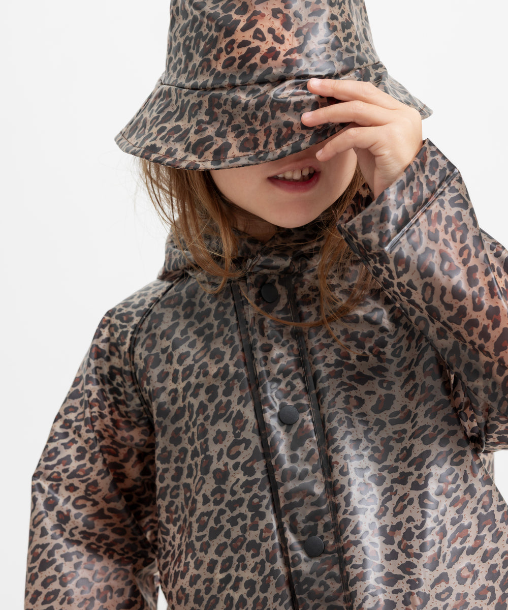 Barn iført leopardmønstret regnjakke og regnhat