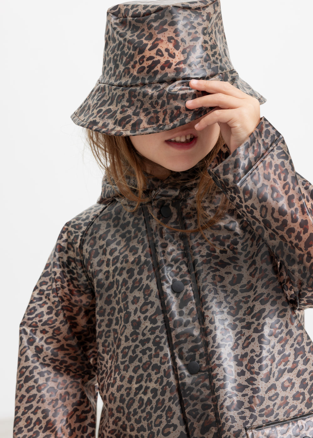 Barn iført leopardmønstret regnjakke og regnhat