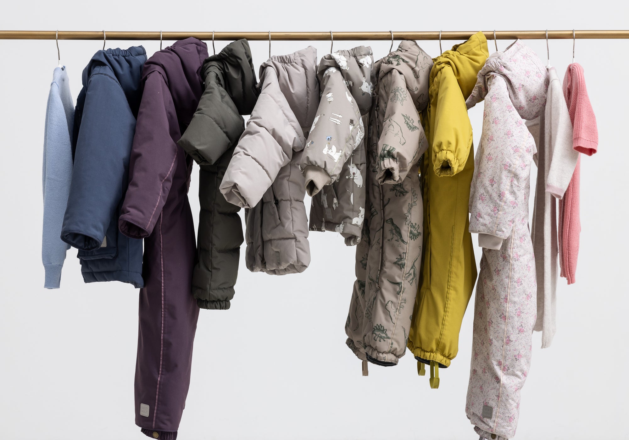 Vinterovertøj til børn og baby i forskellige farver og mønstre hængende på bøjler